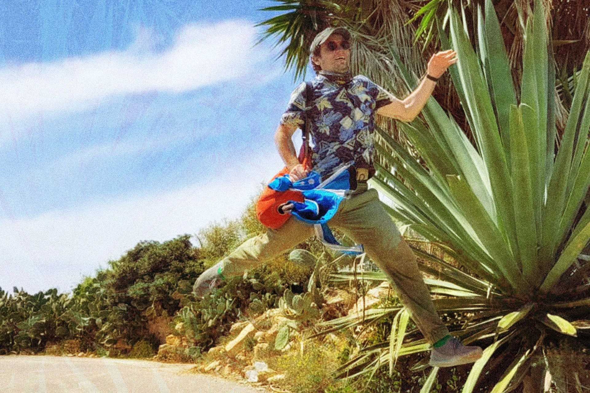 Andrei Apopei jumping mid-air beside an agave on a sunny field trip